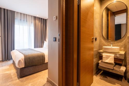 a hotel room with a bed and a sink at Casablanca City Center Maarif in Casablanca