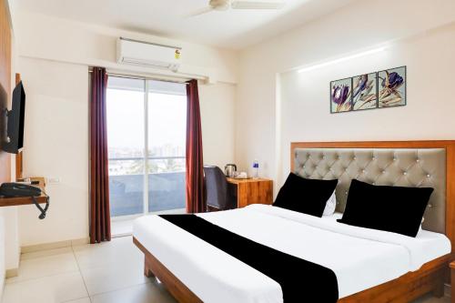 a bedroom with a large bed and a window at Super Townhouse Lohegaon Near Pune Airport formerly Landmark Regency in Pune