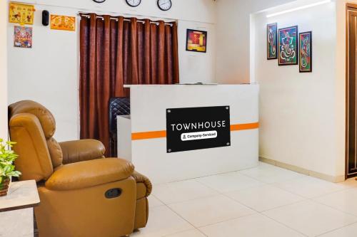 a waiting room with a chair and a tv at Super Townhouse Lohegaon Near Pune Airport formerly Landmark Regency in Pune