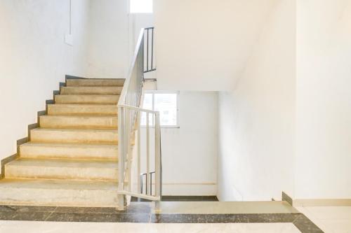 a staircase in a building with a metal handrail at Super Townhouse Lohegaon Near Pune Airport formerly Landmark Regency in Pune