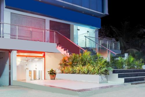 a building with stairs and plants in front of it at Super Townhouse Lohegaon Near Pune Airport formerly Landmark Regency in Pune