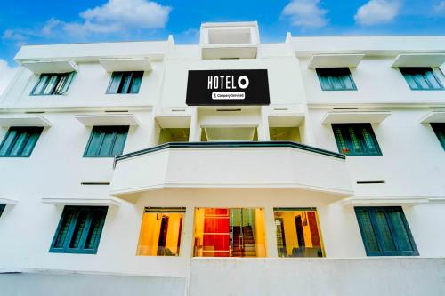 a white building with a hotel sign on it at Super Hotel O Kazhakootam Near Technopark Phase 2 in Trivandrum