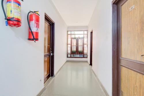 an empty hallway with a fire extinguisher on the wall at Super Hotel O Hari Singh High Street Formerly City Star in Jawāharnagar