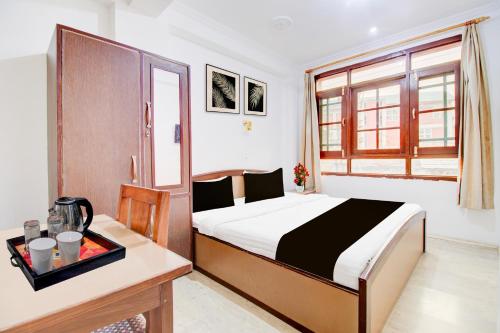 a bedroom with a bed and a desk and a window at Super Hotel O Hari Singh High Street Formerly City Star in Jawāharnagar