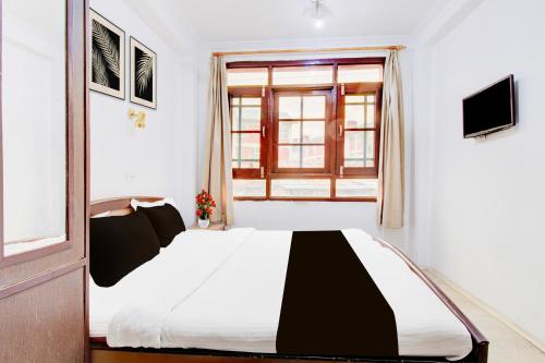 a bedroom with a bed and a window at Super Hotel O Hari Singh High Street Formerly City Star in Jawāharnagar