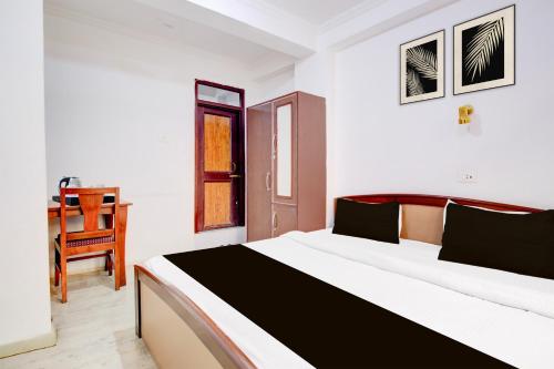 a bedroom with a bed and a chair in it at Super Hotel O Hari Singh High Street Formerly City Star in Jawāharnagar
