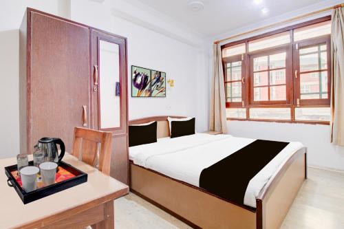 a bedroom with a bed and a table and a window at Super Hotel O Hari Singh High Street Formerly City Star in Jawāharnagar