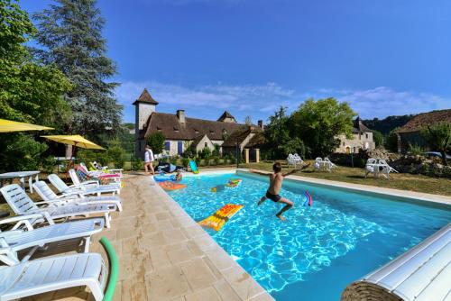 a man is jumping into a swimming pool at Manoir de Foussac in Floirac