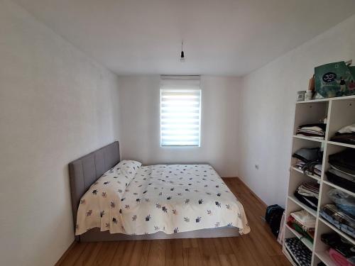 a small bedroom with a bed and a window at Tomić 