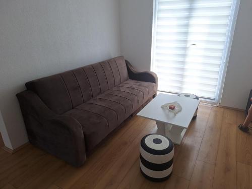 a brown couch in a living room with a table at Tomić 