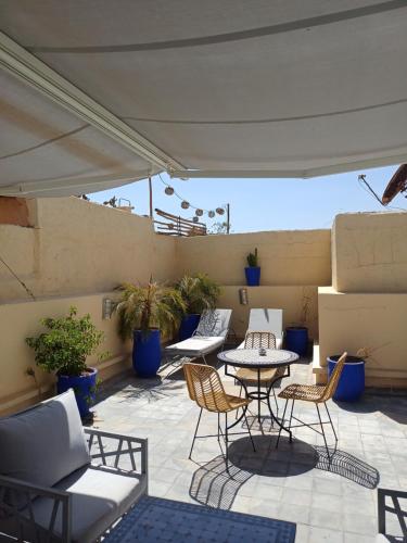 a patio with tables and chairs on a roof at Riad Kasbah 117 in Marrakech