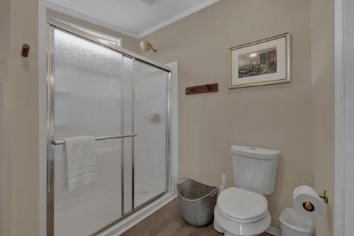 a bathroom with a toilet and a glass shower at Sage: Peaceful Hill Country Retreat with Hot-Tub! in Morris Ranch