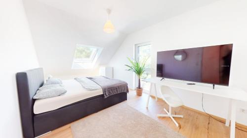 a bedroom with a bed with a desk and a tv at TLA TDY Kurzzeitvermietung Haus in Kindsbach