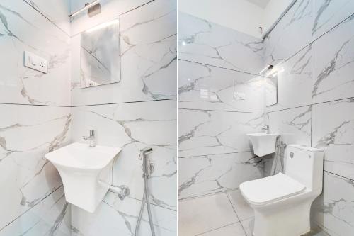 a white bathroom with a toilet and a sink at Super Collection O Westhill Near Govt Engg College in Calicut