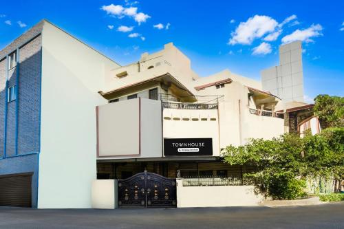 un grand bâtiment blanc avec une enseigne dessus dans l'établissement Super Townhouse Townvilla Guesthouse, à Ameerpet
