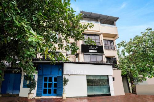 a building with a blue door and trees at Super Collection O Andheri Near Mumbai Airport Formerly We Stay in Mumbai