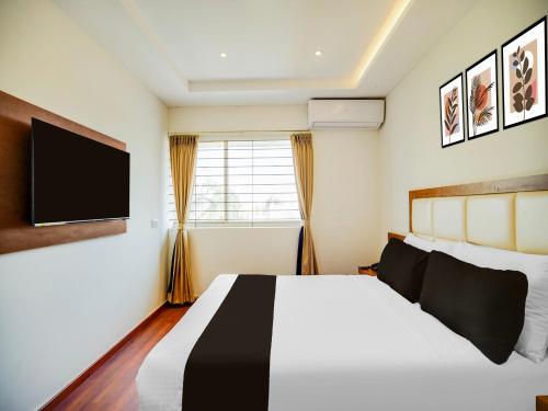 バンガロールにあるSuper Townhouse Ramamurthy Nagar West Formerly Phoenix Hotelのベッドと薄型テレビのある寝室