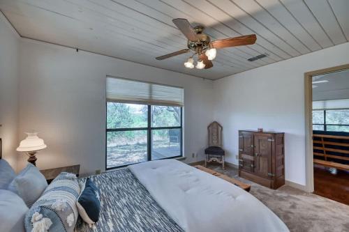 a bedroom with a ceiling fan and a bed at StunningHome on The Blanco River in Flugrath