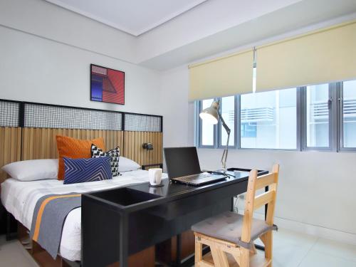 Una cama o camas en una habitación de Relaxing Apt Bgc Business Ready with 84inch Cinema