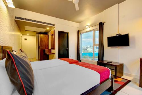 a hotel room with a bed and a television at Super Townhouse Ulsoor in Bengaluru