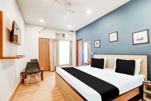 une chambre avec un lit et un mur bleu dans l'établissement Super Collection O Palam Near Railway Station, à New Delhi