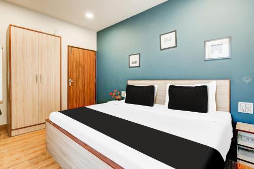 une chambre avec un grand lit avec un mur bleu dans l'établissement Super Collection O Palam Near Railway Station, à New Delhi