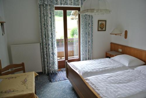 a bedroom with a bed and a large window at Treindlhof in Fuschl am See