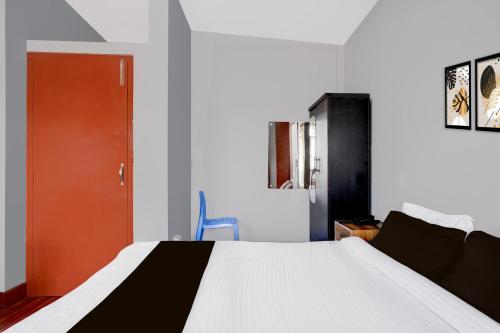 Un dormitorio con una cama y una puerta roja. en Super Collection O SRS Residency, en Shillong