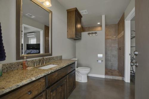 a bathroom with a sink and a toilet and a mirror at Let's Go Tubing! Awesome House-Next to River! in Third Crossing