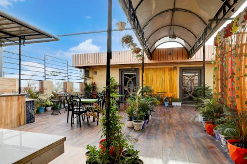 an indoor patio with tables and potted plants at Super Townhouse Hyderabad Gate IIT BHU Formerly RK Heights in Varanasi