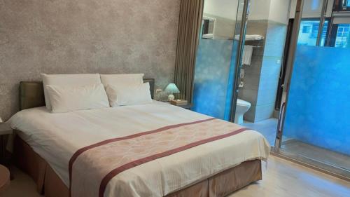 a bedroom with a large bed and a shower at A-SAN Hot-Spring Hotel in Jiaoxi