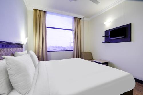 a hotel room with a large bed and a window at Palette MG Road Ernakulam Formerly Harbour View Residency in Cochin