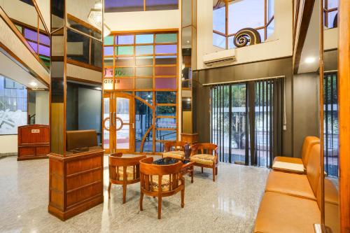 a lobby with a table and chairs and a tv at Palette MG Road Ernakulam Formerly Harbour View Residency in Cochin