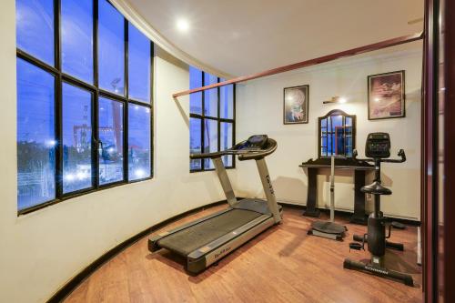 a room with a gym with a treadmill and windows at Palette MG Road Ernakulam Formerly Harbour View Residency in Cochin