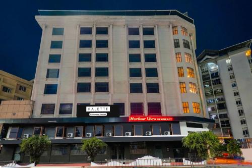a tall white building with a sign on it at Palette MG Road Ernakulam Formerly Harbour View Residency in Cochin