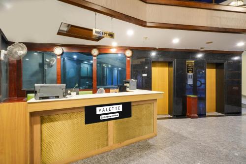 a hotel lobby with a bar with a sign on it at Palette MG Road Ernakulam Formerly Harbour View Residency in Cochin