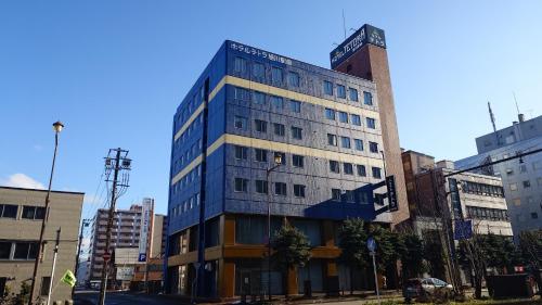 a tall blue building on a city street at HOTEL TETORA ASAHIKAWA EKIMAE - Vacation STAY 91502v in Asahikawa