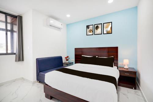 a bedroom with a large bed and a blue wall at Super Townhouse Jeevan Bima Nagar Indranagar in Bengaluru