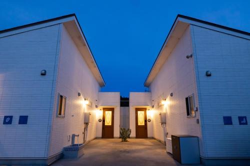 two large white buildings with two doors at night at COCO VILLA 南房総 Dog Stay in Minamiboso