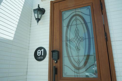 a wooden door with a sign on a house at COCO VILLA 南房総 Dog Stay in Minamiboso