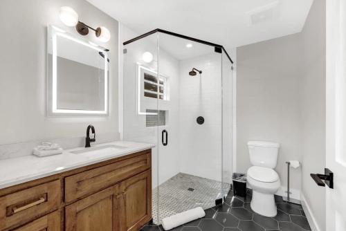 a bathroom with a shower and a toilet and a sink at The Grove B Stylish Cottage - Walk to Main in Fredericksburg
