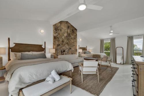 a bedroom with a large bed and a stone wall at Grasslands Pool Hot Tub Hill Country Views in Johnson City