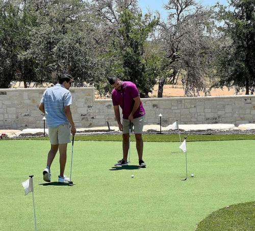 two men playing golf on a golf course at Resort at Fredericksburg Unit 21 in Rocky Hill