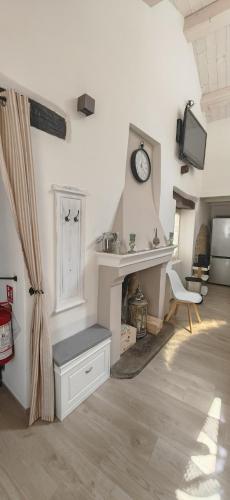 a living room with a fireplace and a clock on the wall at Casa Nonna Maria in Petrella Guidi