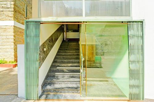 a staircase leading up to a building with a glass door at Super Hotel O Kaveri Road Mysore in Mysore