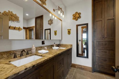 a bathroom with two sinks and a large mirror at West End Lodge Resort Style Pool! in Fredericksburg