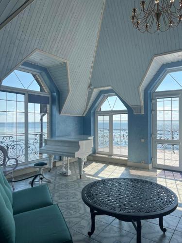 a living room with a piano and a table at Dacha Del Mar in Yasnogorodka