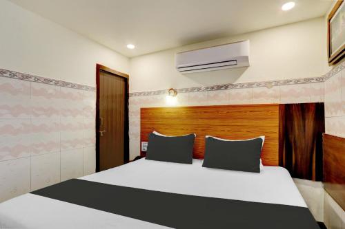 a bedroom with a large white bed and a wooden headboard at Collection O M G Road in Trivandrum