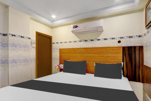 a bedroom with a bed and a air conditioner at Collection O M G Road in Trivandrum