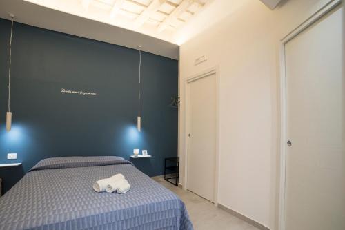 a bedroom with a bed with a blue wall at Holiday House Trapani in Trapani